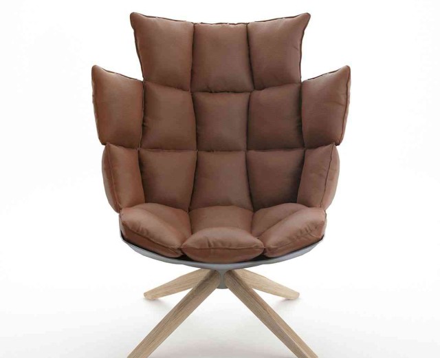 A brown chair with wooden legs and cushion.