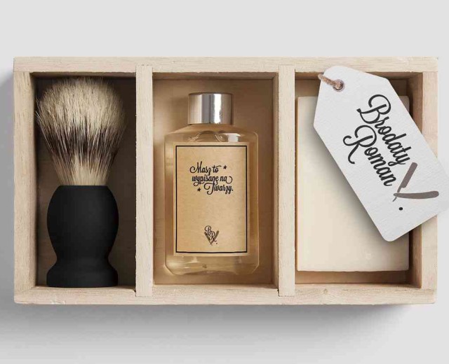 A wooden box with a shaving brush and soap in it.