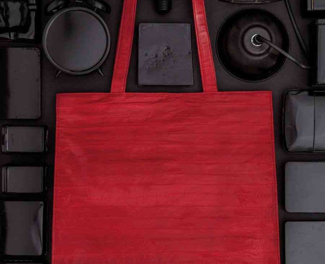 A red bag is surrounded by various items.