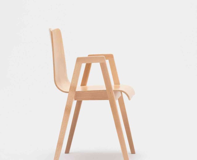 A wooden chair with four legs and two arms.